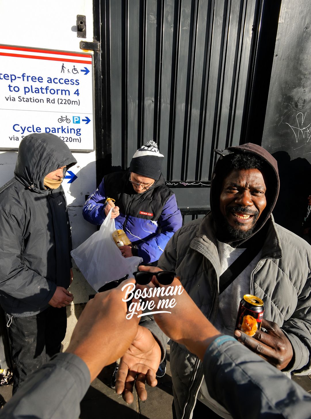 Handing hot food to a man near the step-free entrance at West Croydon station
